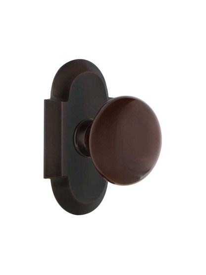 Arched Rosette Door Set with Brown Porcelain Knobs in Timeless Bronze.